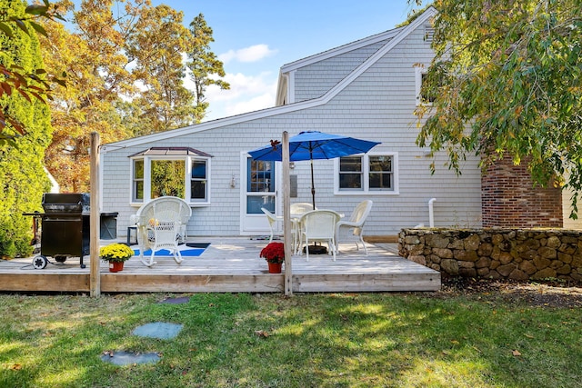 back of property featuring a wooden deck and a yard