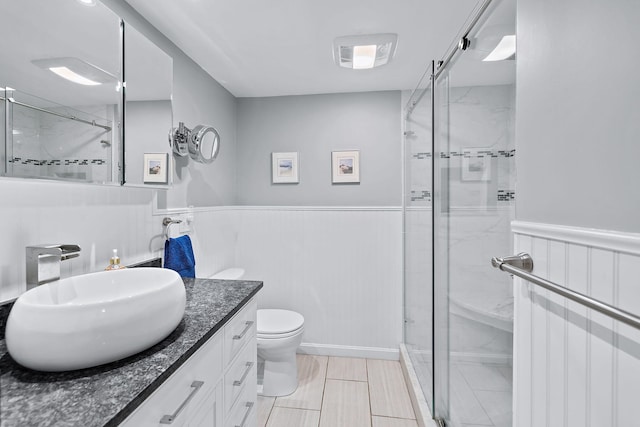 bathroom featuring toilet, vanity, and walk in shower