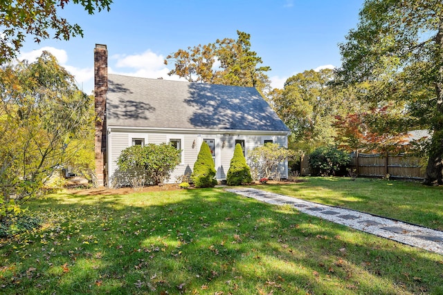 cape cod home with a front lawn