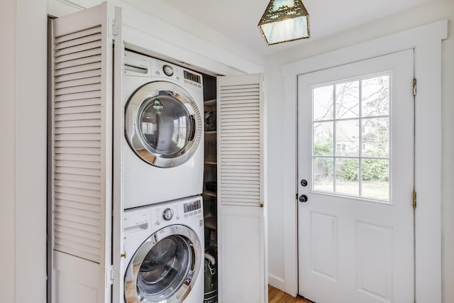 clothes washing area with estacked washer and dryer
