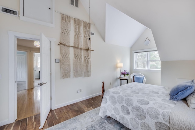bedroom with wood finished floors, vaulted ceiling, and baseboards