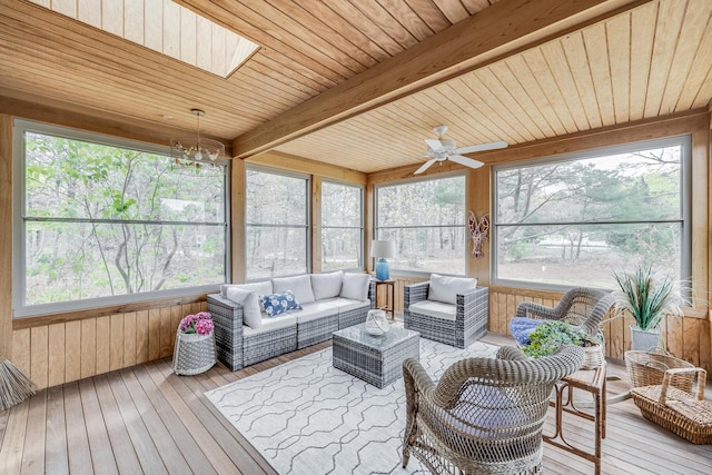 sunroom / solarium with a ceiling fan, beam ceiling, an outdoor living space, a chandelier, and a skylight
