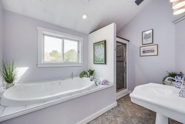 bathroom featuring a shower stall, a garden tub, baseboards, and a sink