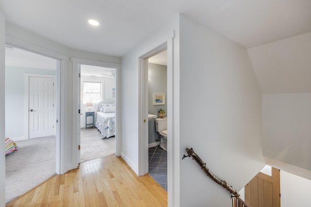 hall featuring light wood-style floors, baseboards, and recessed lighting