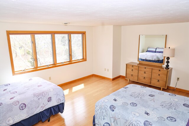 bedroom with light wood-type flooring and baseboards