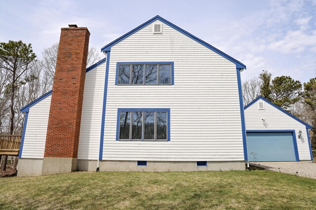 view of side of home featuring a chimney, gravel driveway, a yard, and crawl space