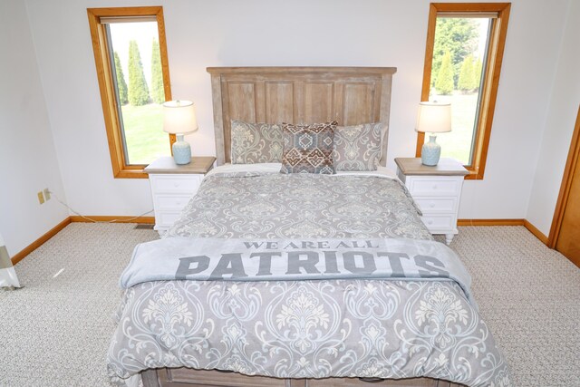 bedroom featuring baseboards and light colored carpet