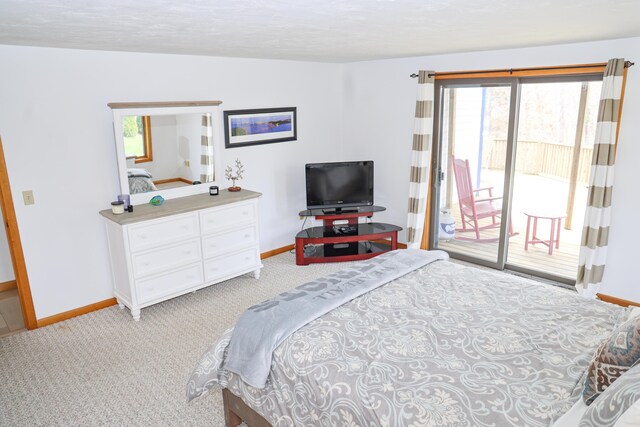 bedroom featuring baseboards, multiple windows, and access to exterior