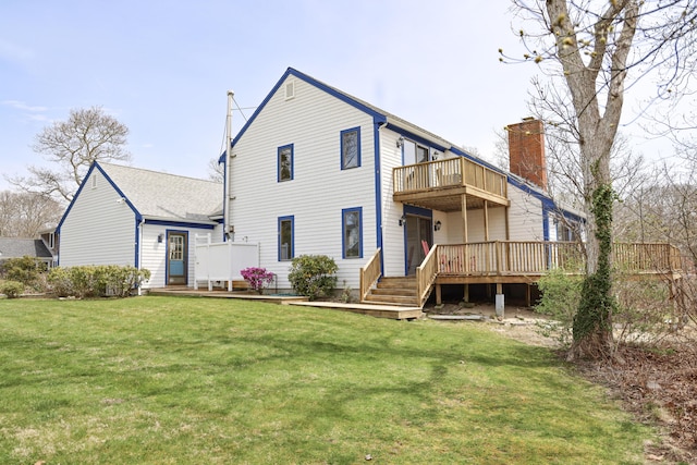 back of house featuring roof with shingles, a balcony, a chimney, and a deck