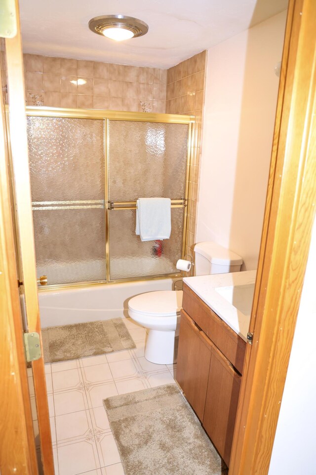 full bathroom featuring bath / shower combo with glass door, vanity, and toilet