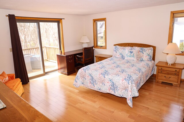 bedroom featuring access to exterior and wood finished floors