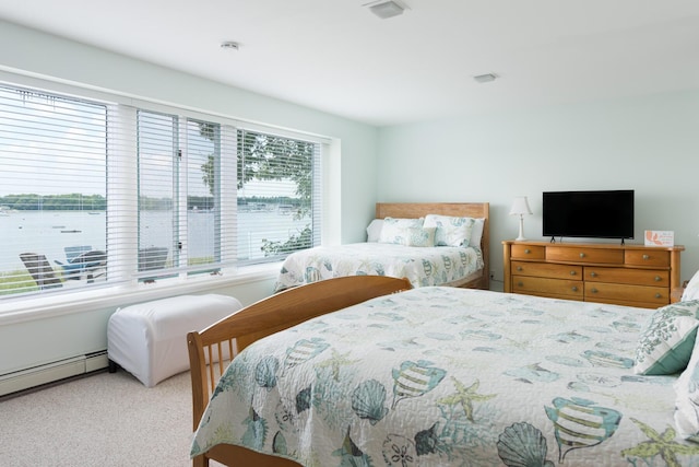 carpeted bedroom featuring baseboard heating and multiple windows