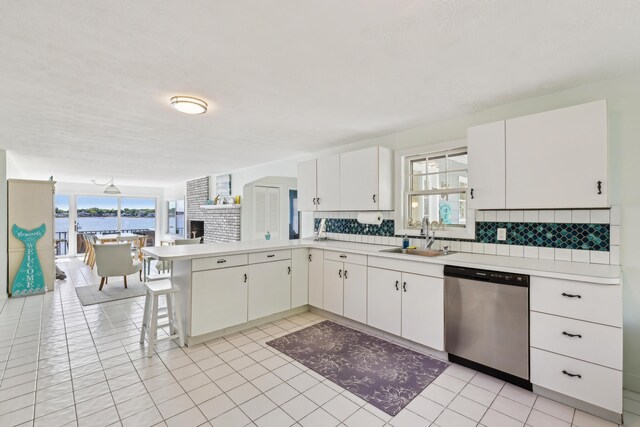 57 Oak St, Wareham, MA 02571 - kitchen featuring stainless steel dishwasher, a sink, light countertops, backsplash, and a peninsula
