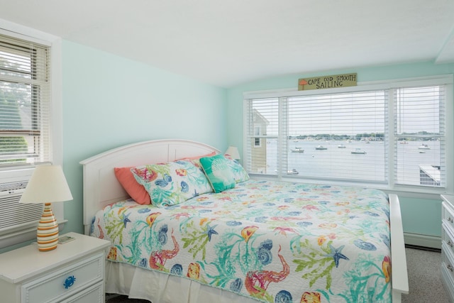 carpeted bedroom with baseboard heating and vaulted ceiling