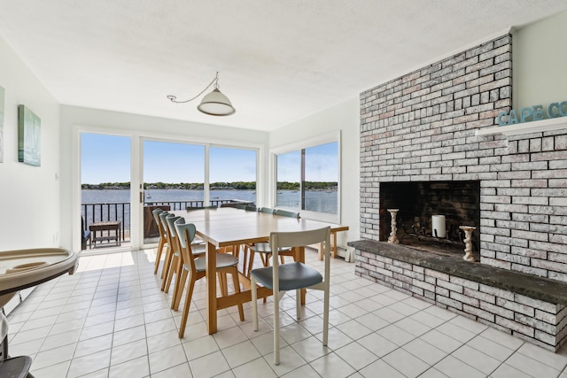 57 Oak St, Wareham, MA 02571 - dining space with a fireplace, a water view, and light tile patterned flooring