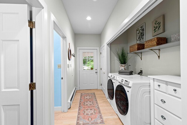 laundry area with washing machine and clothes dryer, light wood-style flooring, baseboard heating, baseboards, and laundry area
