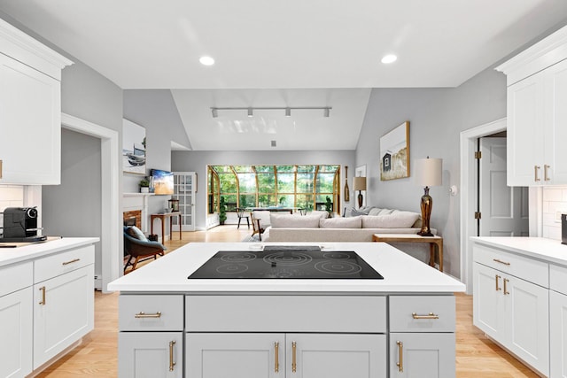 kitchen with lofted ceiling, open floor plan, light countertops, and black electric cooktop