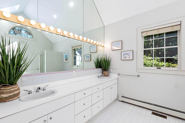 bathroom with double vanity, lofted ceiling with skylight, a baseboard heating unit, and a sink