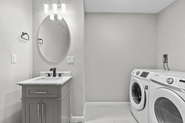 laundry room with washing machine and clothes dryer, cabinet space, a sink, and baseboards