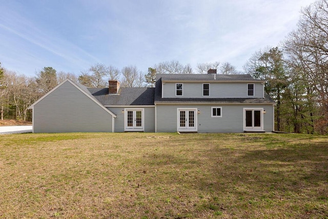 back of house featuring a yard, french doors, and a chimney