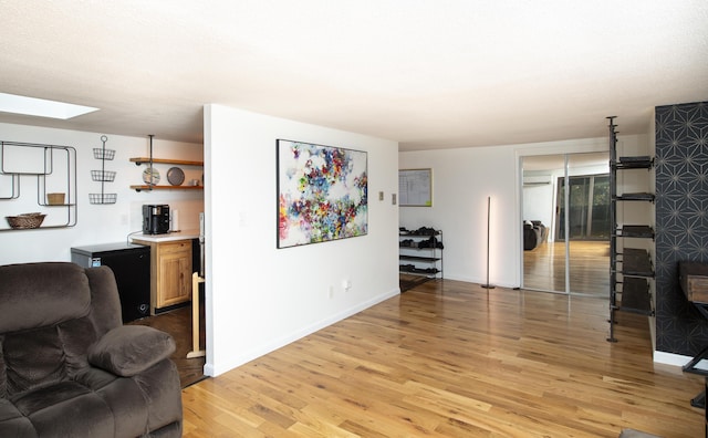 living room featuring a skylight and light hardwood / wood-style floors