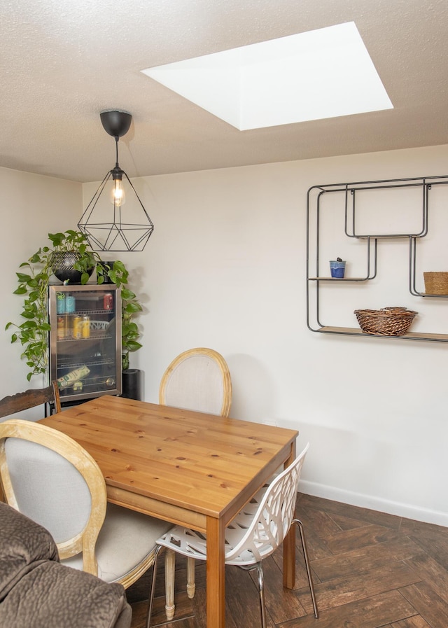 dining space with a skylight and dark parquet floors