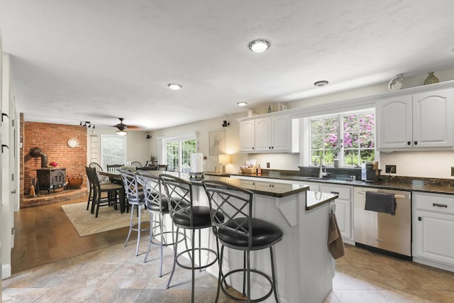 5 Lancaster Ln, Bourne, MA 02532 - kitchen with dishwasher, a sink, a kitchen breakfast bar, dark countertops, and white cabinetry