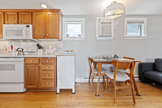544 Shore Rd Unit 9, Truro, MA 02666 - kitchen with white appliances, light wood-style flooring, brown cabinetry, an AC wall unit, and light countertops