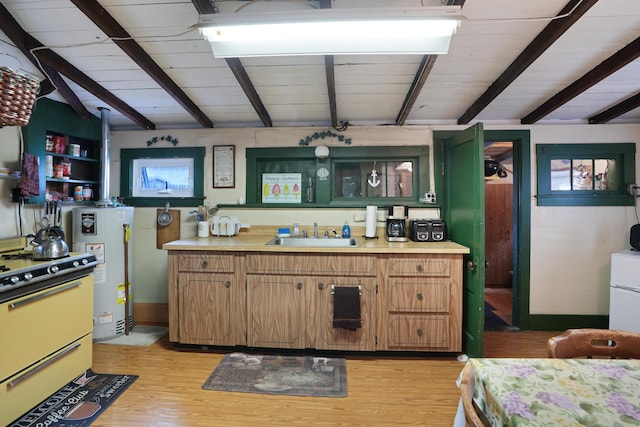 kitchen with beamed ceiling, light hardwood / wood-style floors, sink, gas water heater, and stove