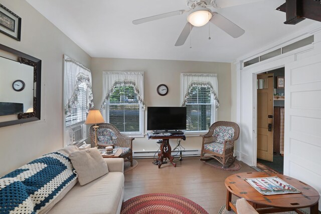 living room with hardwood / wood-style flooring, cooling unit, a baseboard radiator, and ceiling fan