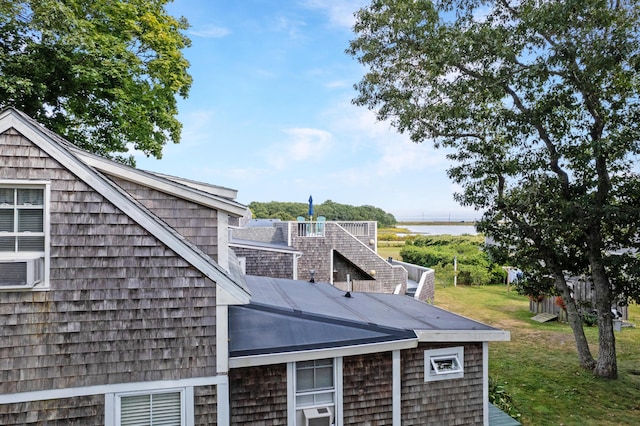 view of side of home featuring cooling unit and a lawn