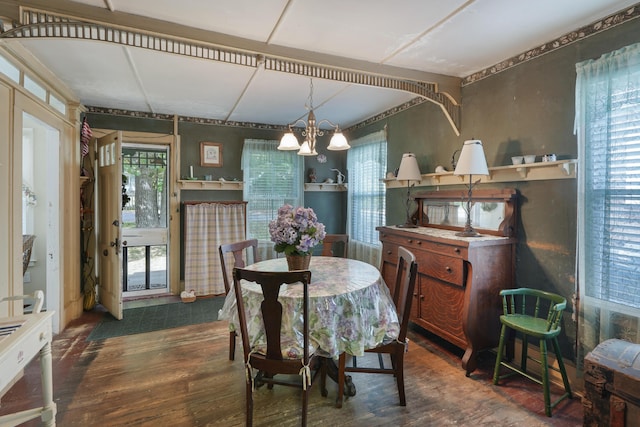 dining area featuring a chandelier, dark wood-type flooring, and plenty of natural light