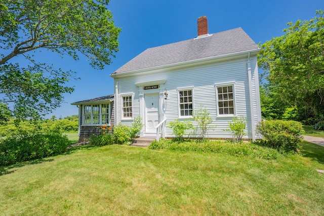 56 Wharf Ln, Yarmouth Port, MA 02675 - view of front facade with a chimney, a front yard, and a shingled roof