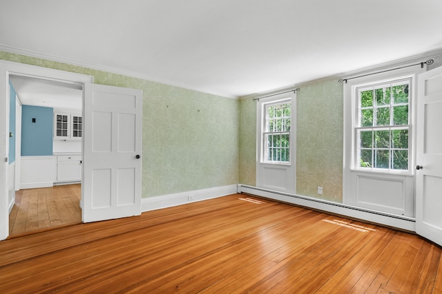 56 Wharf Ln, Yarmouth Port, MA 02675 - empty room featuring a baseboard heating unit, hardwood / wood-style flooring, and crown molding