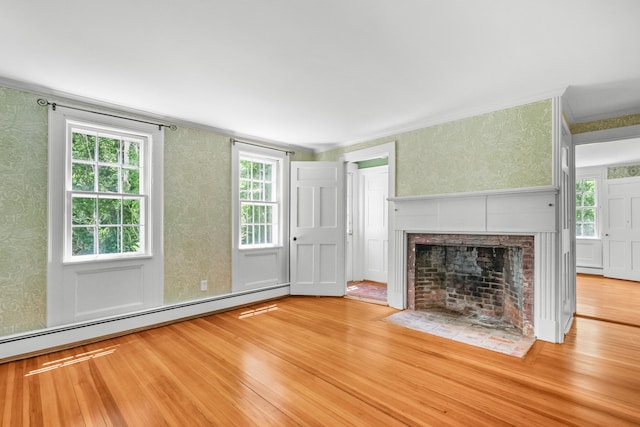 56 Wharf Ln, Yarmouth Port, MA 02675 - unfurnished living room with a baseboard radiator, wood finished floors, wallpapered walls, a tiled fireplace, and crown molding