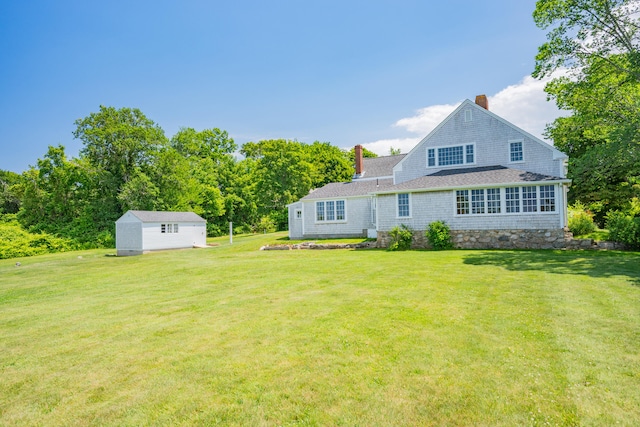 56 Wharf Ln, Yarmouth Port, MA 02675 - back of house with a chimney, a lawn, and a shed
