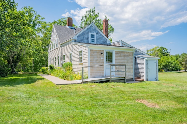 56 Wharf Ln, Yarmouth Port, MA 02675 - back of house with a chimney and a lawn
