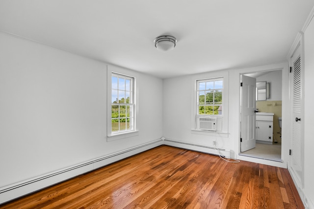 56 Wharf Ln, Yarmouth Port, MA 02675 - unfurnished bedroom featuring wood finished floors, a baseboard radiator, cooling unit, and connected bathroom