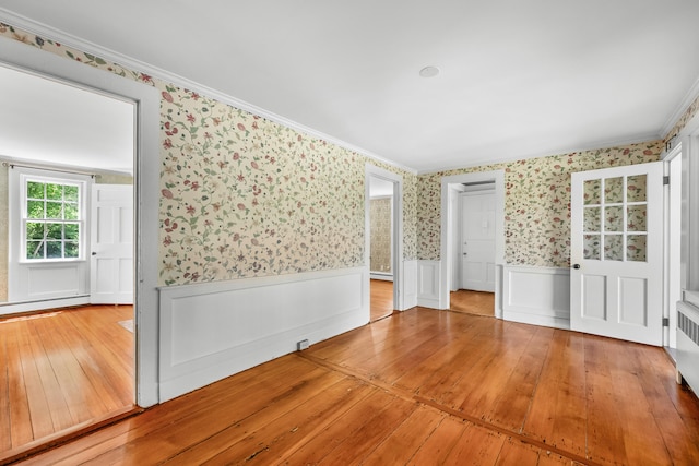 56 Wharf Ln, Yarmouth Port, MA 02675 - spare room featuring wallpapered walls, hardwood / wood-style flooring, a wainscoted wall, a baseboard radiator, and ornamental molding