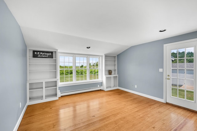 56 Wharf Ln, Yarmouth Port, MA 02675 - empty room with baseboard heating, wood finished floors, healthy amount of natural light, built in shelves, and lofted ceiling
