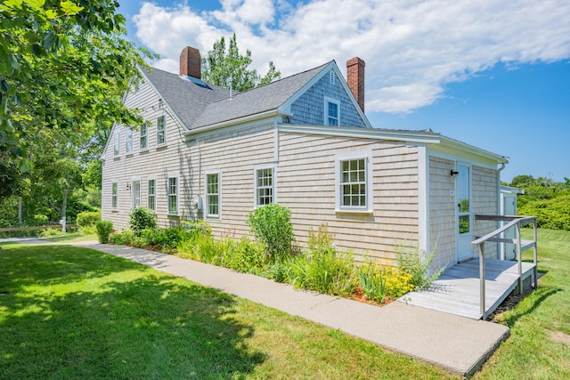 56 Wharf Ln, Yarmouth Port, MA 02675 - view of property exterior featuring a chimney, a lawn, and roof with shingles