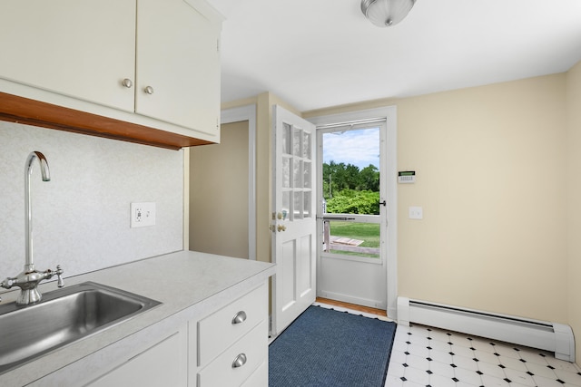 56 Wharf Ln, Yarmouth Port, MA 02675 - kitchen with baseboard heating, white cabinets, light countertops, and light floors