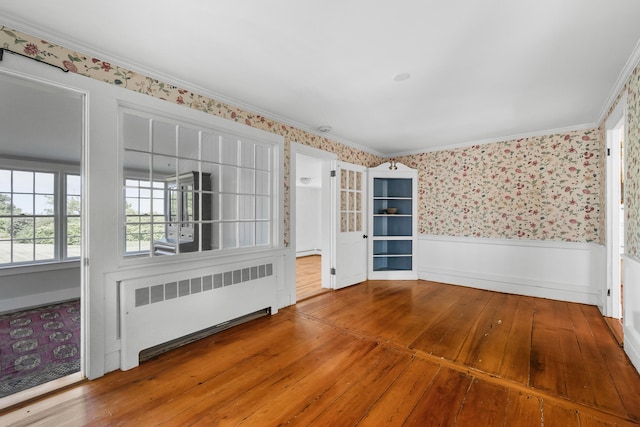 56 Wharf Ln, Yarmouth Port, MA 02675 - unfurnished room with radiator, wainscoting, wallpapered walls, wood-type flooring, and ornamental molding