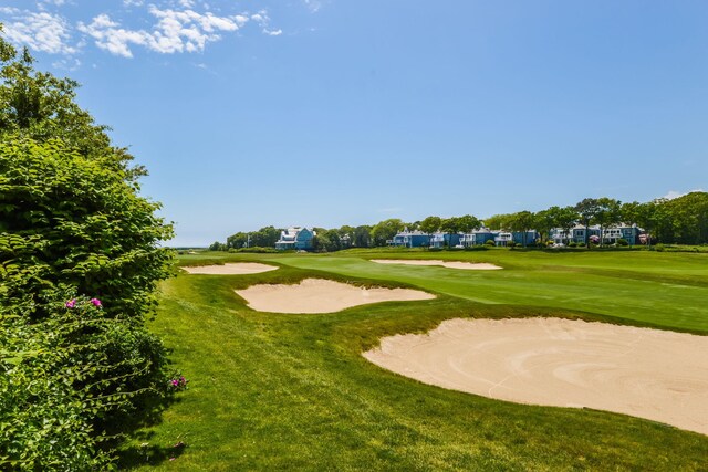 view of community featuring golf course view and a yard