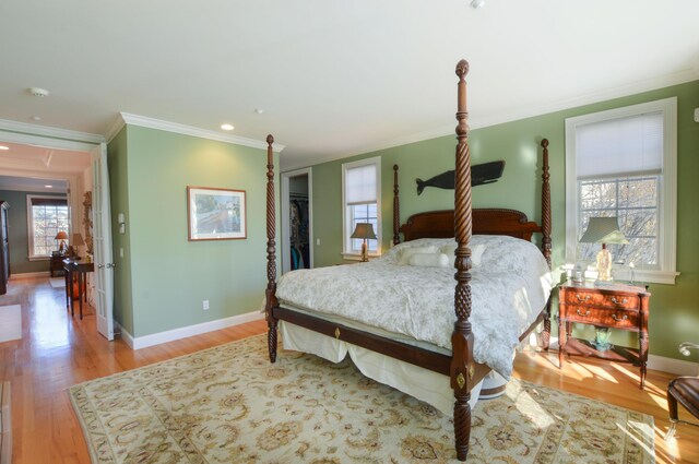 bedroom featuring crown molding, recessed lighting, baseboards, a closet, and wood finished floors