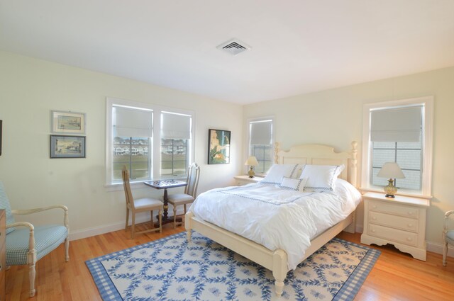 bedroom featuring light wood finished floors, baseboards, and visible vents