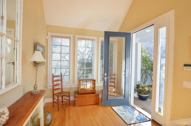 entryway featuring baseboards, lofted ceiling, and wood finished floors