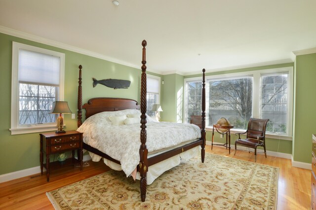 bedroom featuring baseboards, light wood-type flooring, and ornamental molding