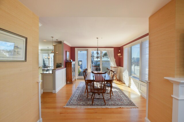 dining area featuring an inviting chandelier, light wood-style floors, and crown molding