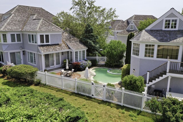 rear view of house with a fenced backyard, a lawn, a gate, and a patio